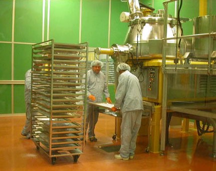 Workers holding a tray containing powder
